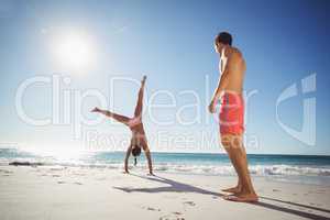 Woman performing somersault on beach