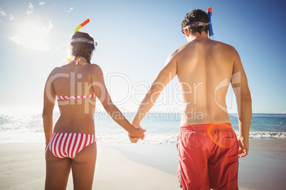 Couple wearing diving mask standing on beach