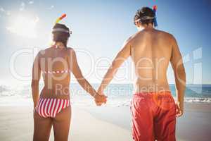 Couple wearing diving mask standing on beach