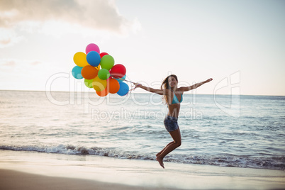 Woman jumping with balloon