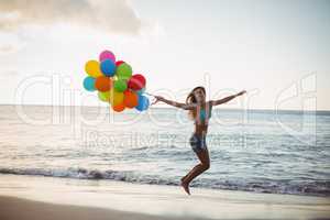 Woman jumping with balloon