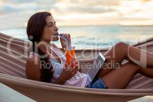 Woman having mocktail while relaxing on a hammock