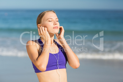 Beautiful young woman listening music while exercising