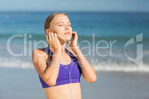 Beautiful young woman listening music while exercising