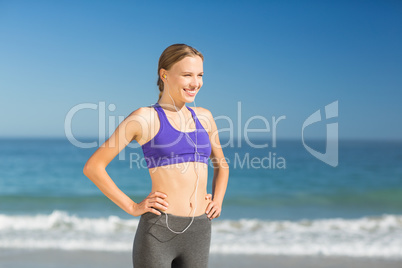 Beautiful young woman listening music while exercising