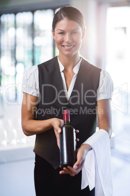 Waitress holding a bottle of red wine and a towel