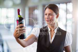 Waitress holding a wine bottle