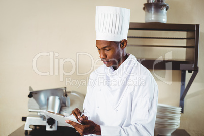 Chef making notes on a clipboard