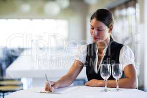 Waitress sitting at the table and writing notes