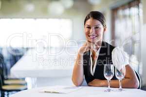 Portrait of smiling waitress sitting at the table
