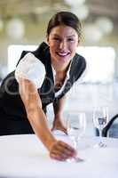 Portrait of smiling waitress setting the table