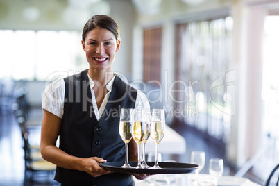 Portrait of waitress holding serving tray with champagne flutesÃ?Â 