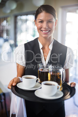 Waitress holding serving tray with coffee cup and pint of beer