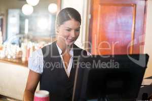 Waitress working on computer at counter