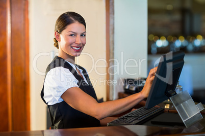 Portrait of waitress using a computer at counter