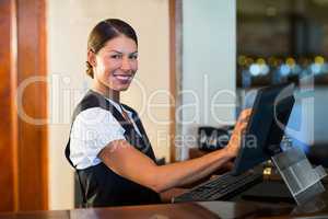 Portrait of waitress using a computer at counter