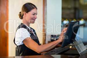 Waitress using a computer at counter
