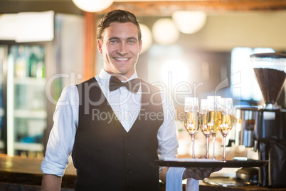 Portrait of waiter holding serving tray with champagne flutesÃ?Â 