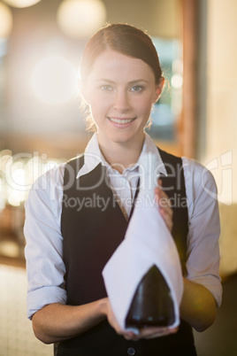 Waitress holding champagne bottle wrapped in towel