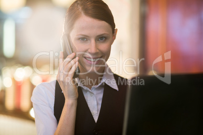 Waitress talking on phone at counter