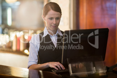 Waitress using a computer at counter