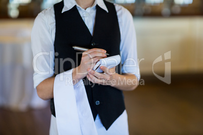Mid section of waitress taking order