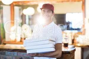Pizza delivery man holding pizza boxes