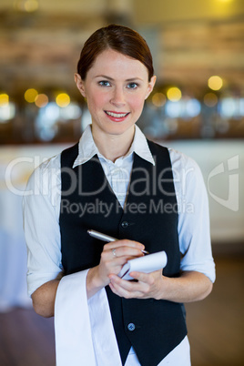 Portrait of smiling waitress taking order