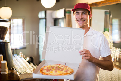 Pizza delivery man showing fresh pizza