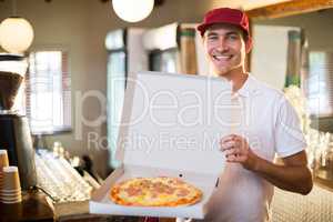 Pizza delivery man showing fresh pizza