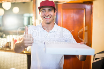Pizza delivery man holding pizza box gesturing thumbs up
