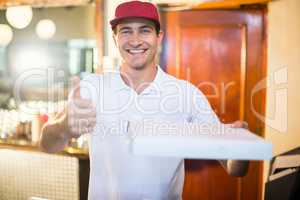 Pizza delivery man holding pizza box gesturing thumbs up