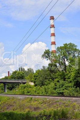 Industrial boiler pipe on a background of green trees