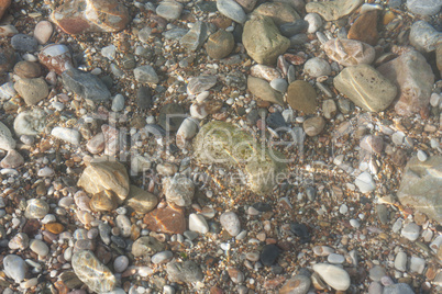 Colorful stones under sea water, with water effect over them