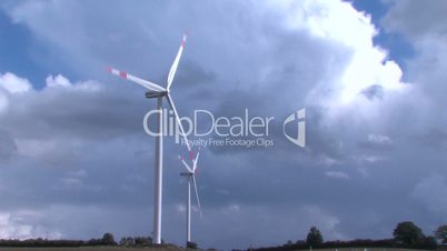 Windräder drehen sich vor dunklen Wolken