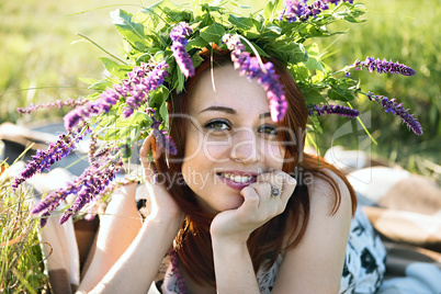 girl with a wreath on his head lying on the grass