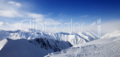 Panoramic view on snowy mountains at sun day