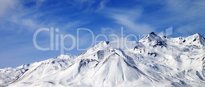 Panoramic view of winter snowy mountains at windy day