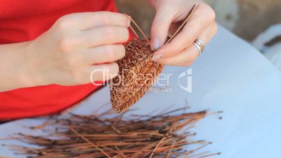 Weaving a vase of pine needles
