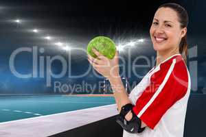 Composite image of sportswoman posing with ball