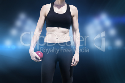 Composite image of sporty woman holding a red ball