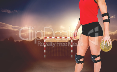 Female athlete with elbow pad holding handball