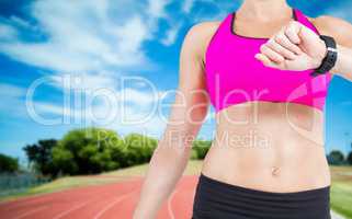 Composite image of female athlete watching her smart watch