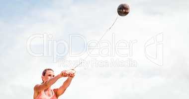 Composite image of portrait of sportswoman practising hammer thr