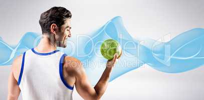 Composite image of happy athlete male holding a ball