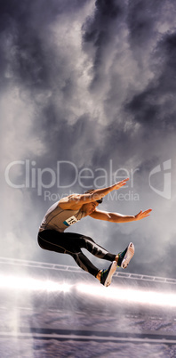 Portrait of sportsman jumping against a stadium