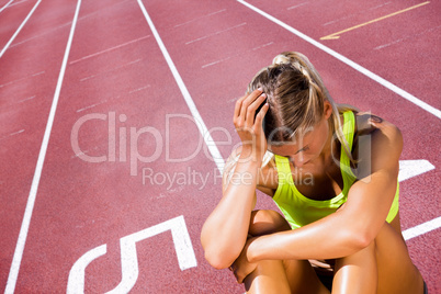 Composite image of sporty woman sitting down and feeling disappo