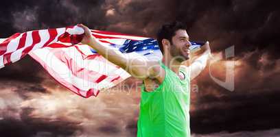 Composite image of happy sportsman holding a american flag