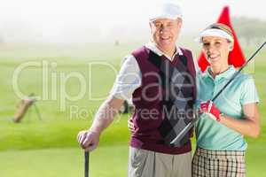 Composite image of couple golf players looking the camera
