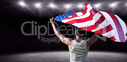 Rear view of athletic man holding the American flag